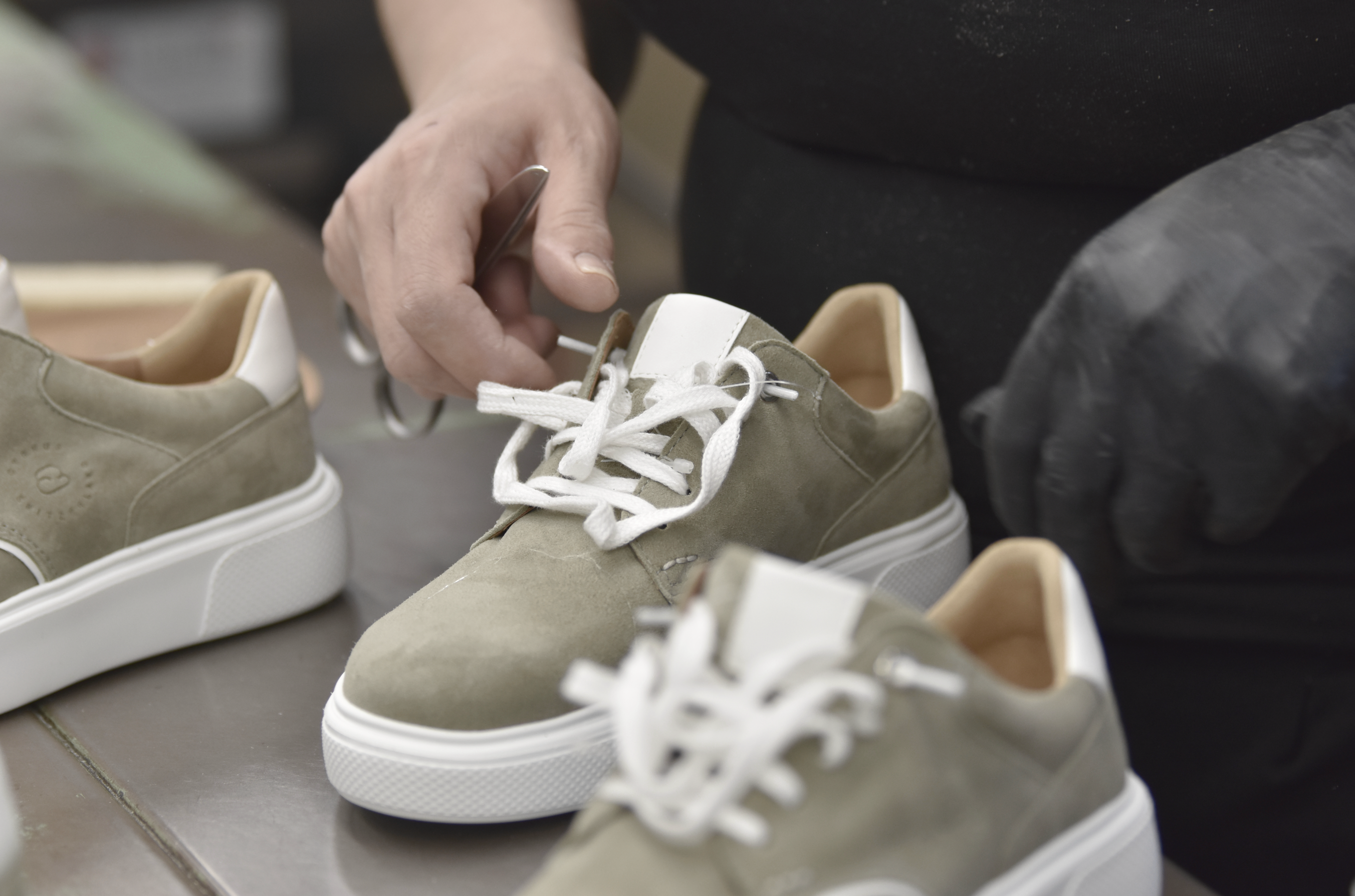 CYBRUS Sneaker ist im Finish der Produktion, in der Endkontrolle werden die Bändel gebunden.