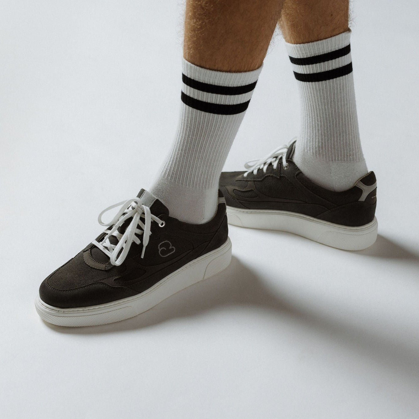 "Männerbeine mit weissen Socken trägt den CYBRUS Sneakers 3600 in grau"
