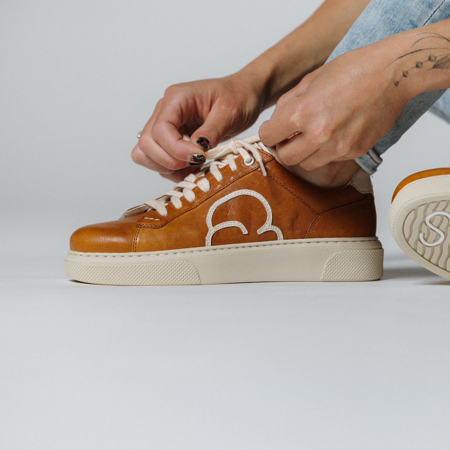 "Frauenfuss mit dem CYBRUS Sneakers 49er in hellbraun creme"