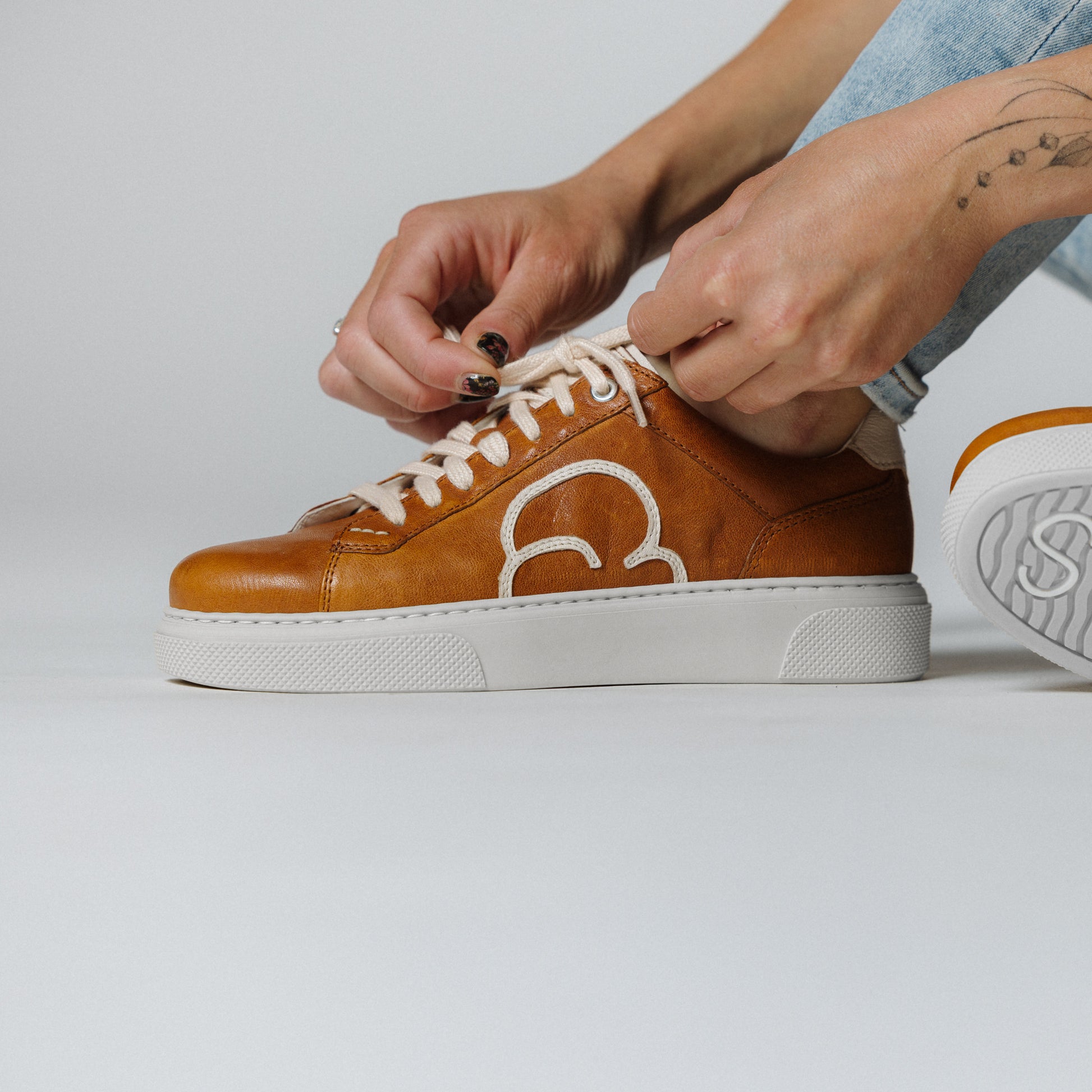 "Frauenfuss mit dem CYBRUS Sneakers 49er in hellbraun creme"